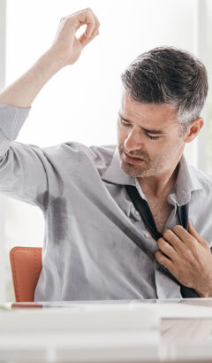 Nervous businessman working in the office, he is sweating and checking his armpits